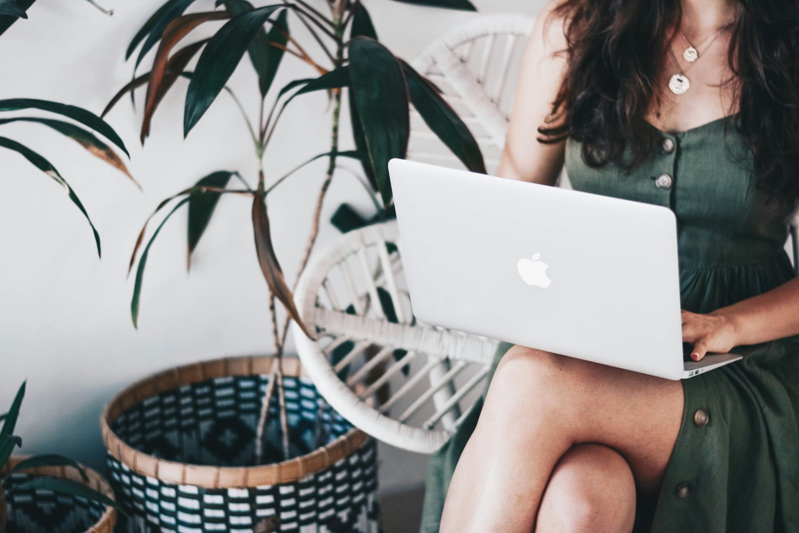 Lady in green dress working on a Mac at a coffee shop